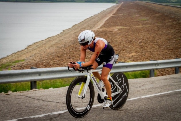 Triathlete riding a bike during Ironman Kansas.