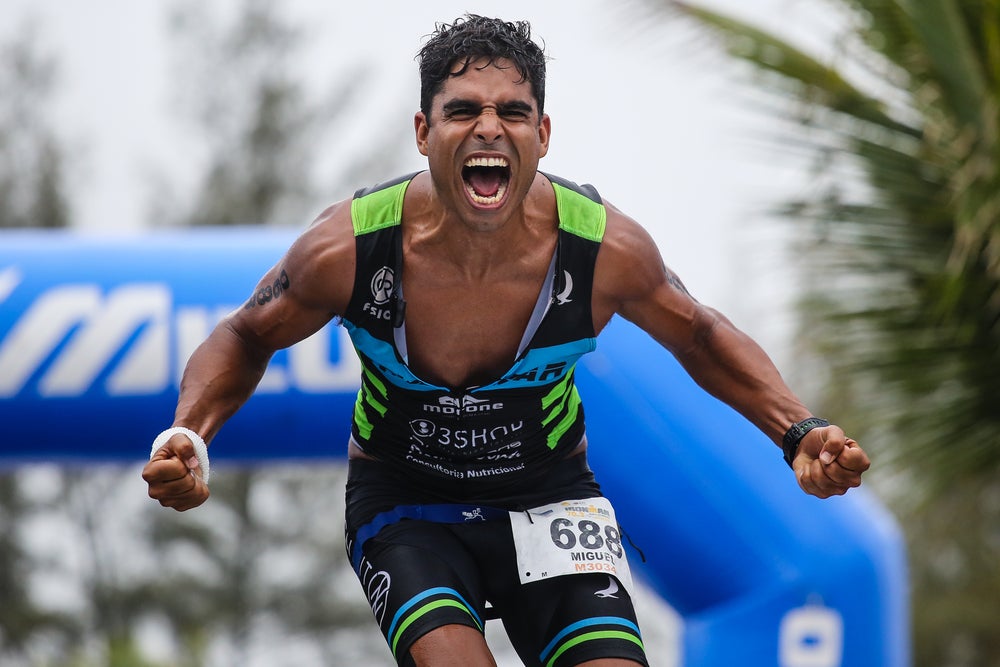 An athlete celebrates after crossing the finish line of Ironman 70.3 Rio de Janeiro. Photo: Shutterstock.com