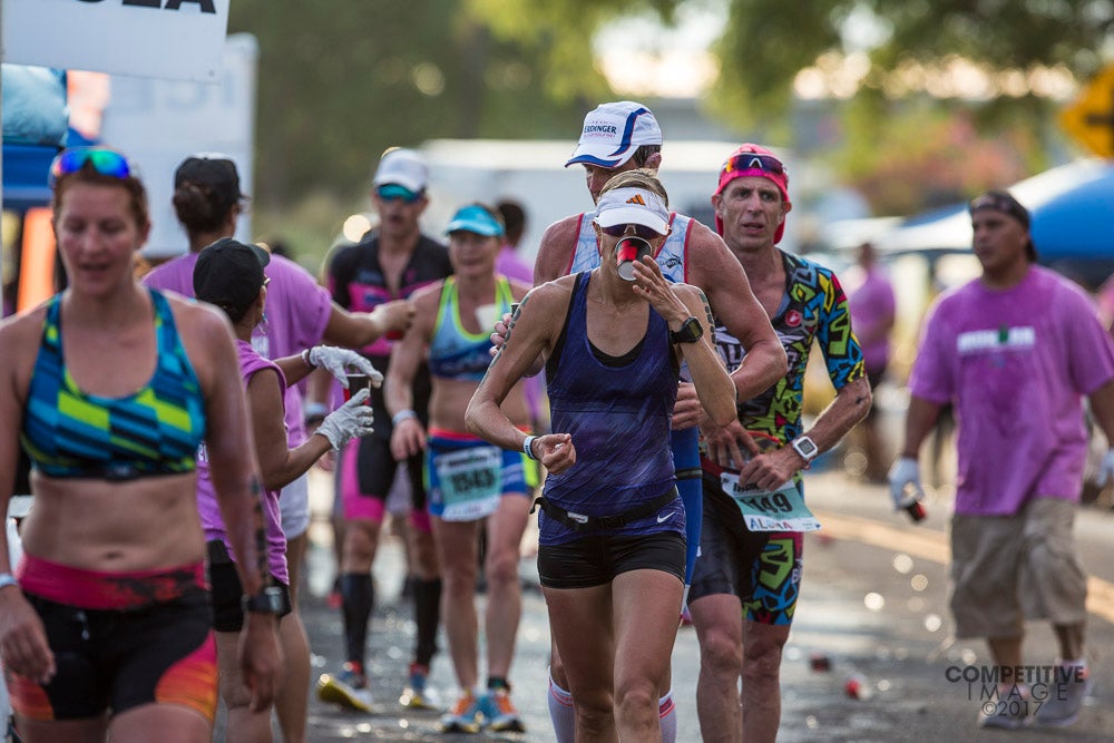Athletes get much needed hydration and nutrition at an aid station at the 2017 Ironman World Championship. Photo: Paul Phillips/Competitive Image