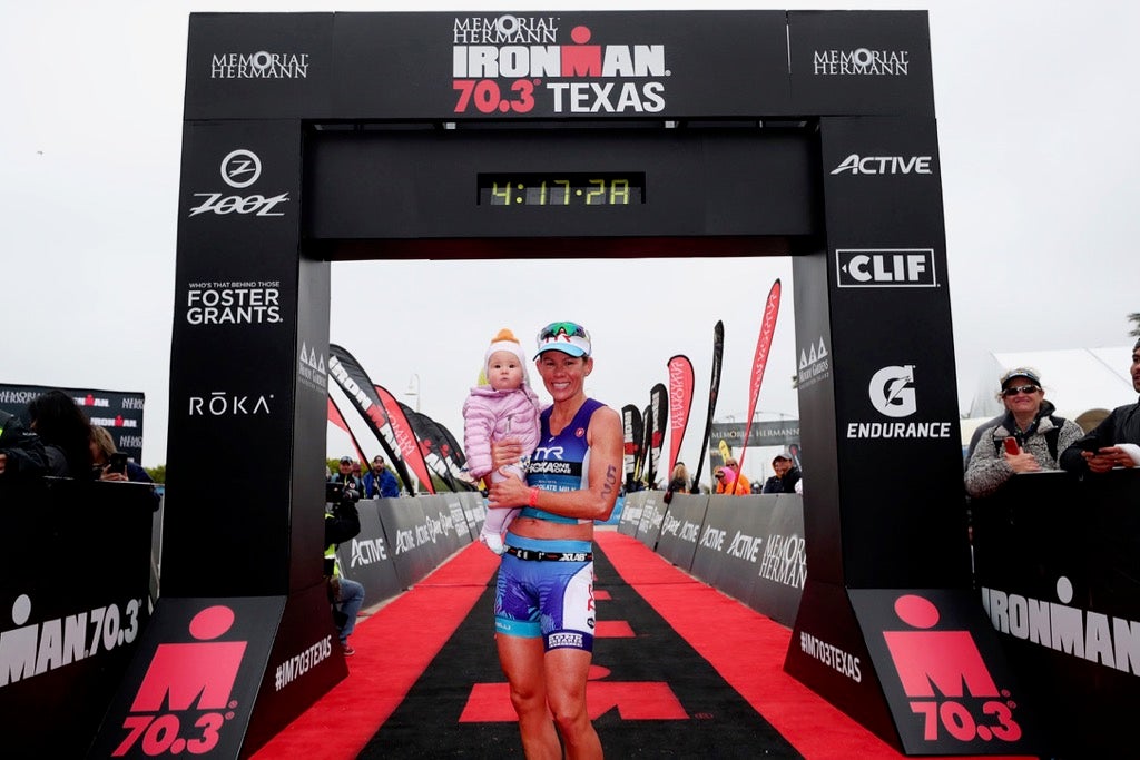 Carfrae gives daughter Izzy a hug at the finish line. Photo: Tom Pennington/Getty Images for Ironman