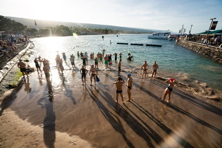 Os atletas vão para um mergulho de treinamento no Kona Pier.  Os moradores de Kona estão furiosos com o Ironman World Championship tomando conta da cidade por dois dias.