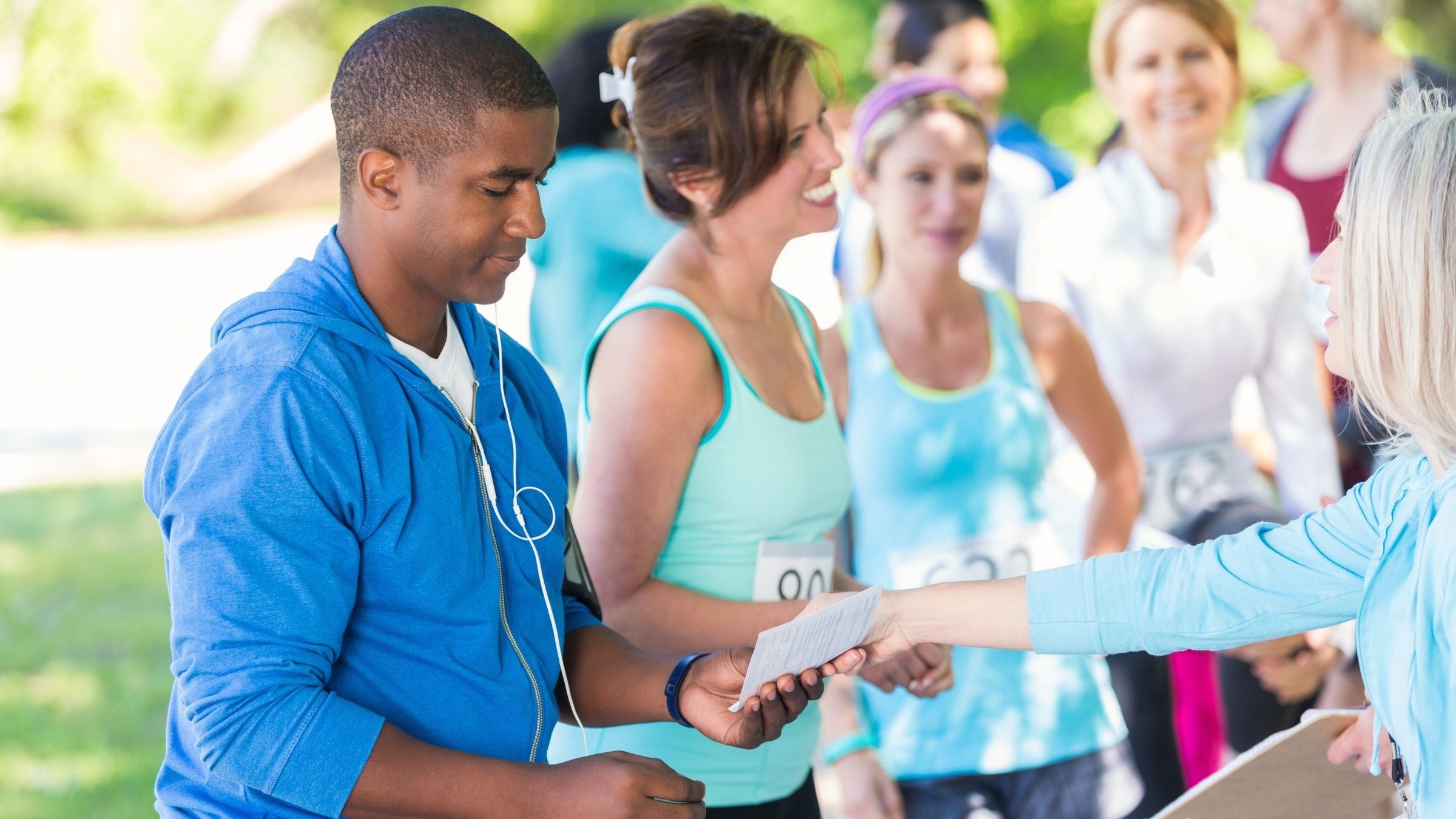 A man picks up his race number at a race registration tent.