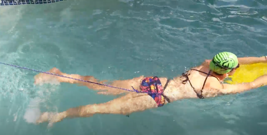 A swimmer demonstrates how to use a Backyard Pool Swim Tether.