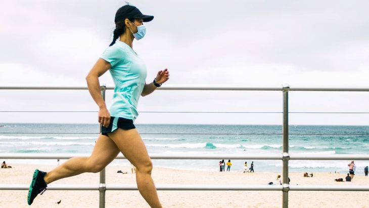 Woman jogging wearing face mask.
