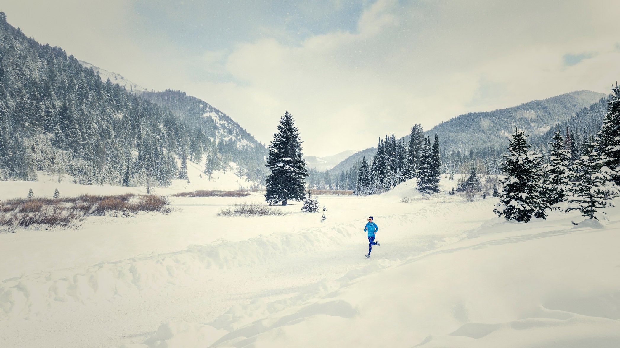 An athlete is running in tough winter conditions.
