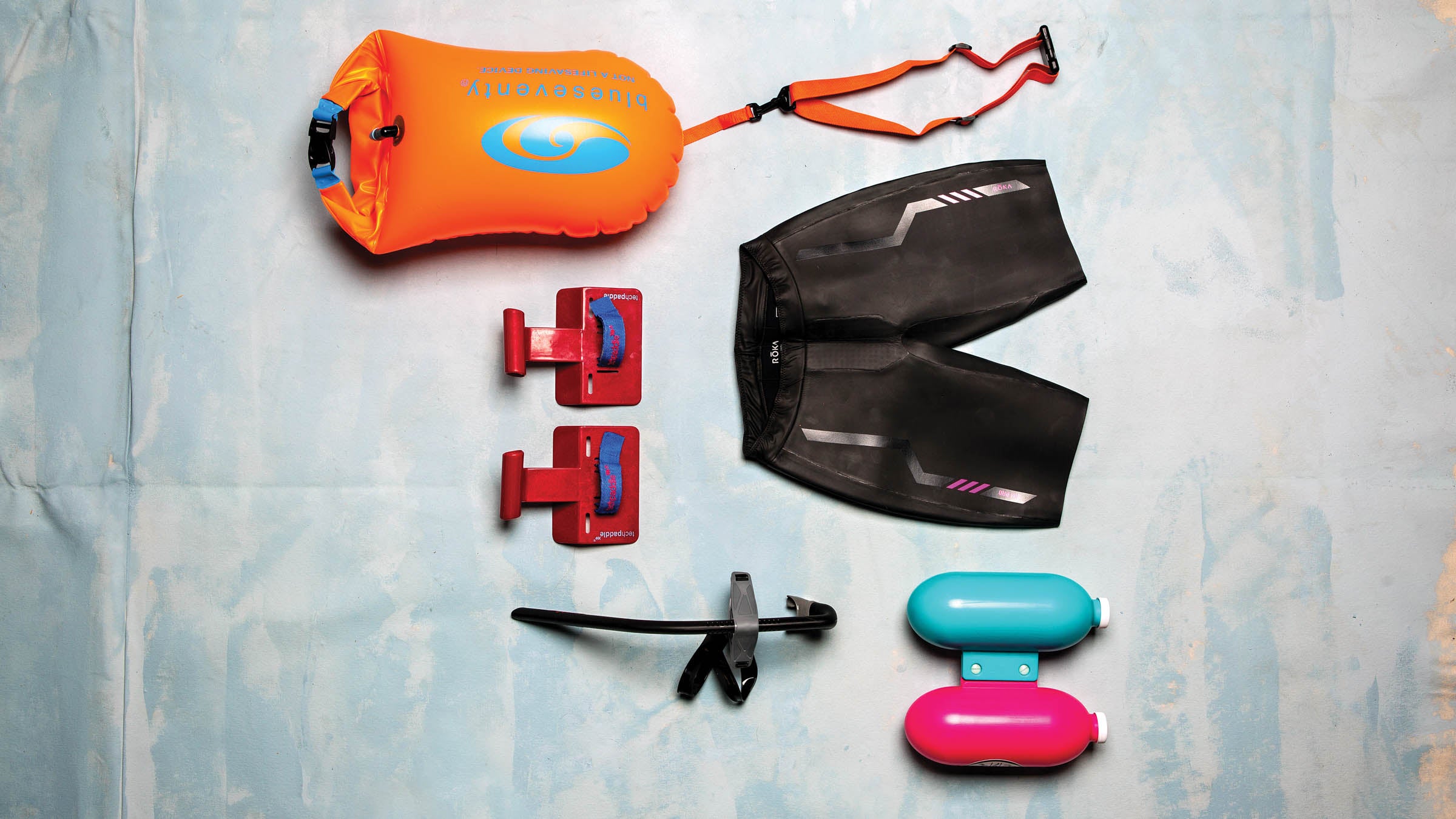 An assortment of swim training devices on a grey background.