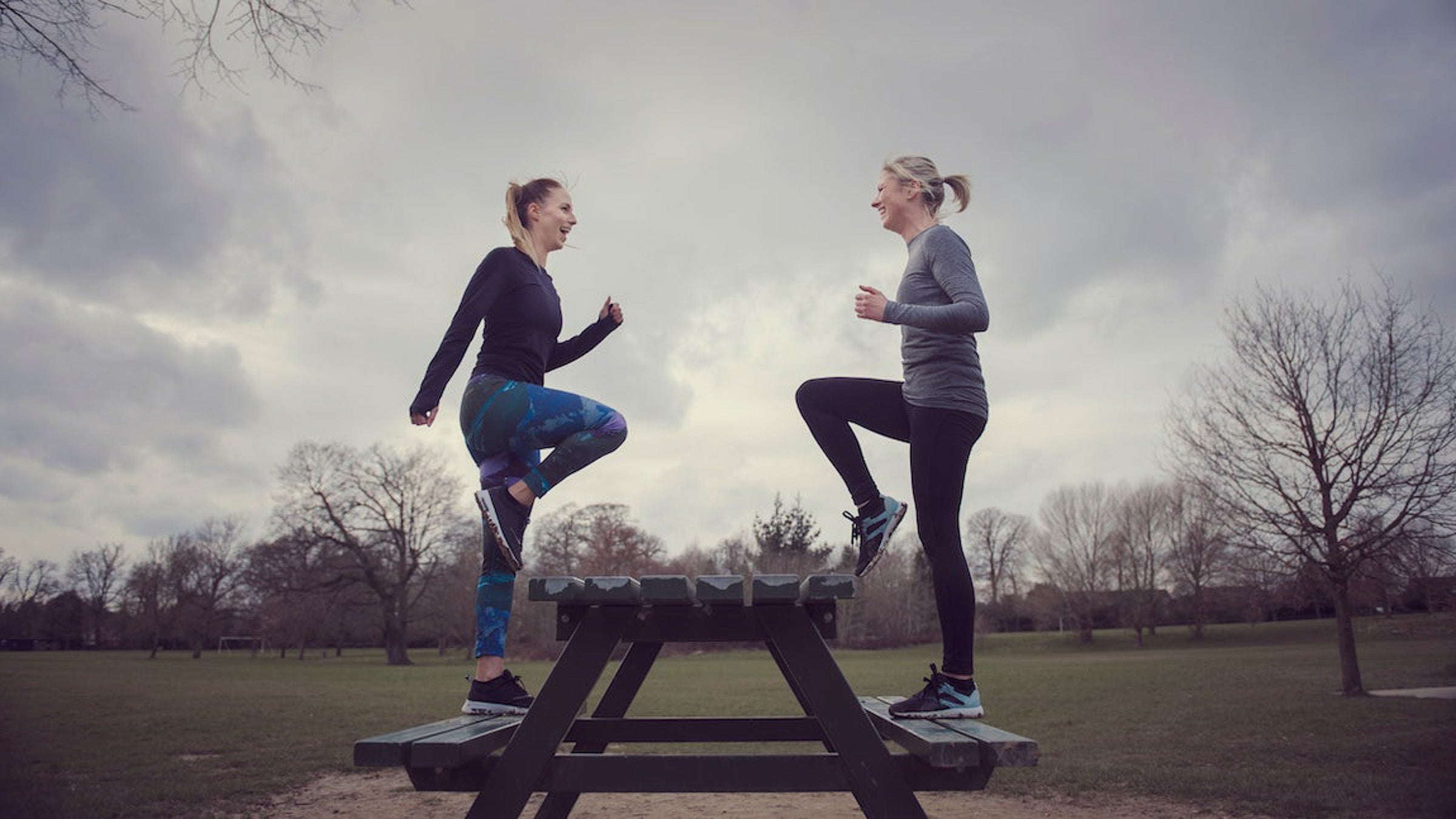 Side view of women doing step ups on picnic bench