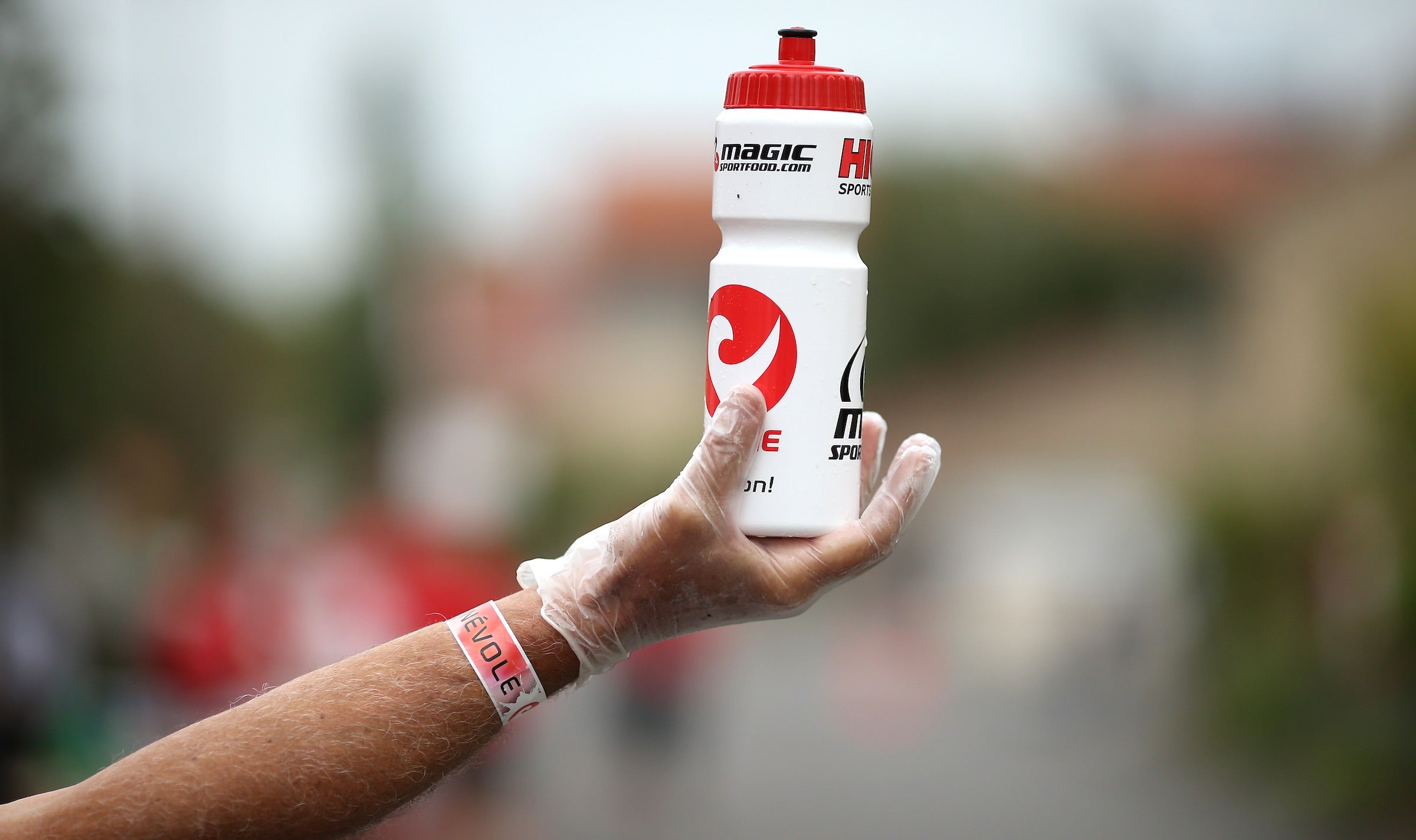 A volunteer holds out a water bottle at Challenge Vichy.