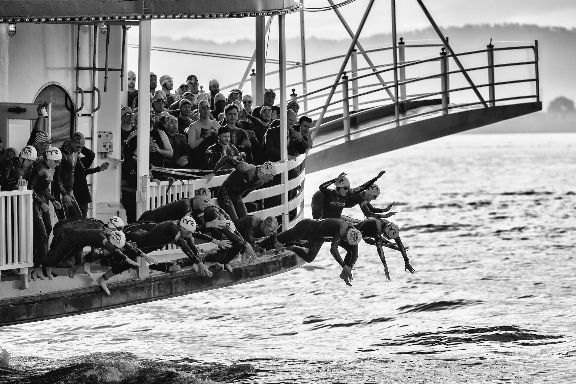 Athletes dive off the ferry at the start of the Escape from Alcatraz triathlon.