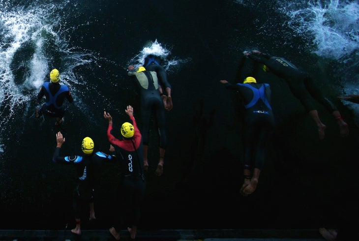 swimmers dive in for the start of alcatraz triathlon