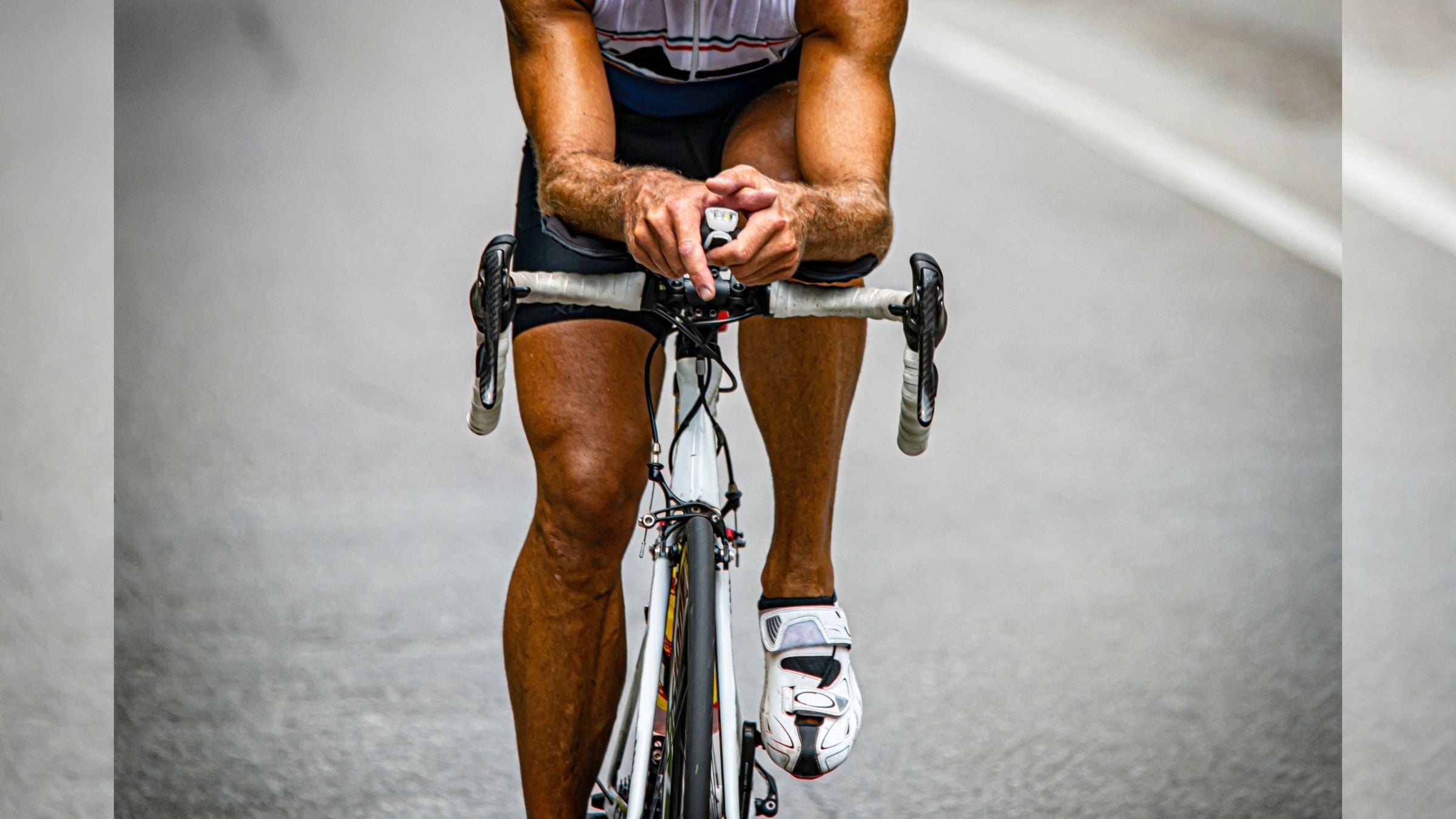 A male triathlete rides a bike. Many triathletes wonder if sweet spot intervals or threshold workouts are better for triathletes.