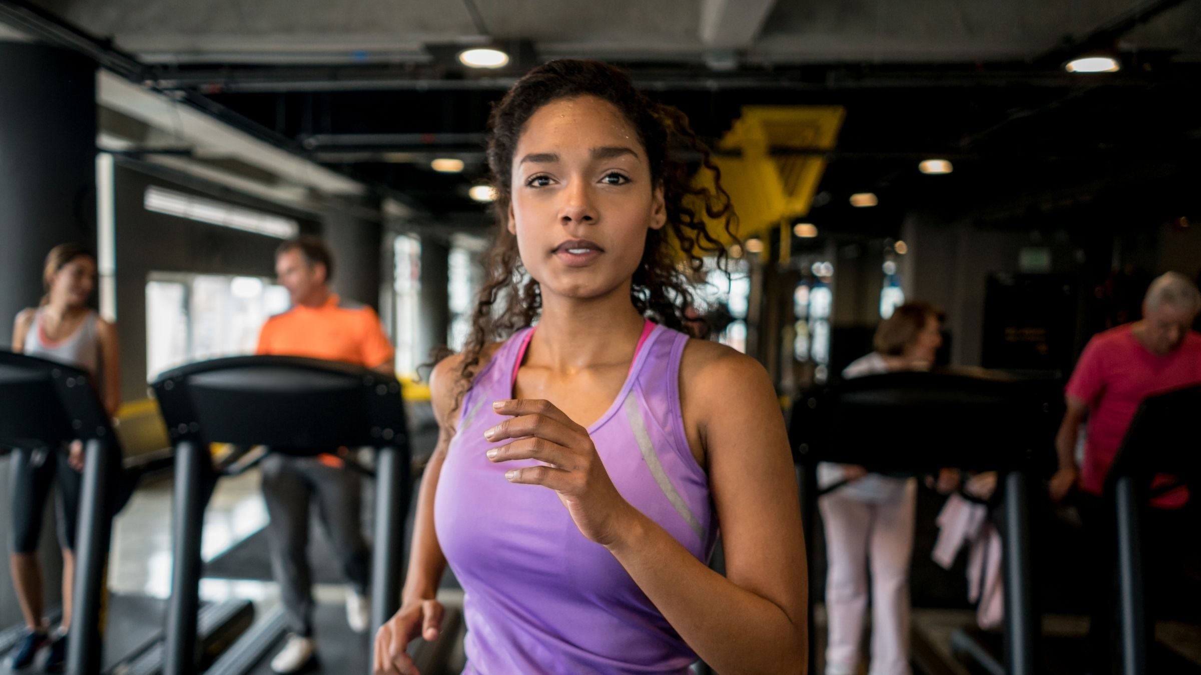 A woman confidently runs on the treadmill because she knows the purpose of her workout.