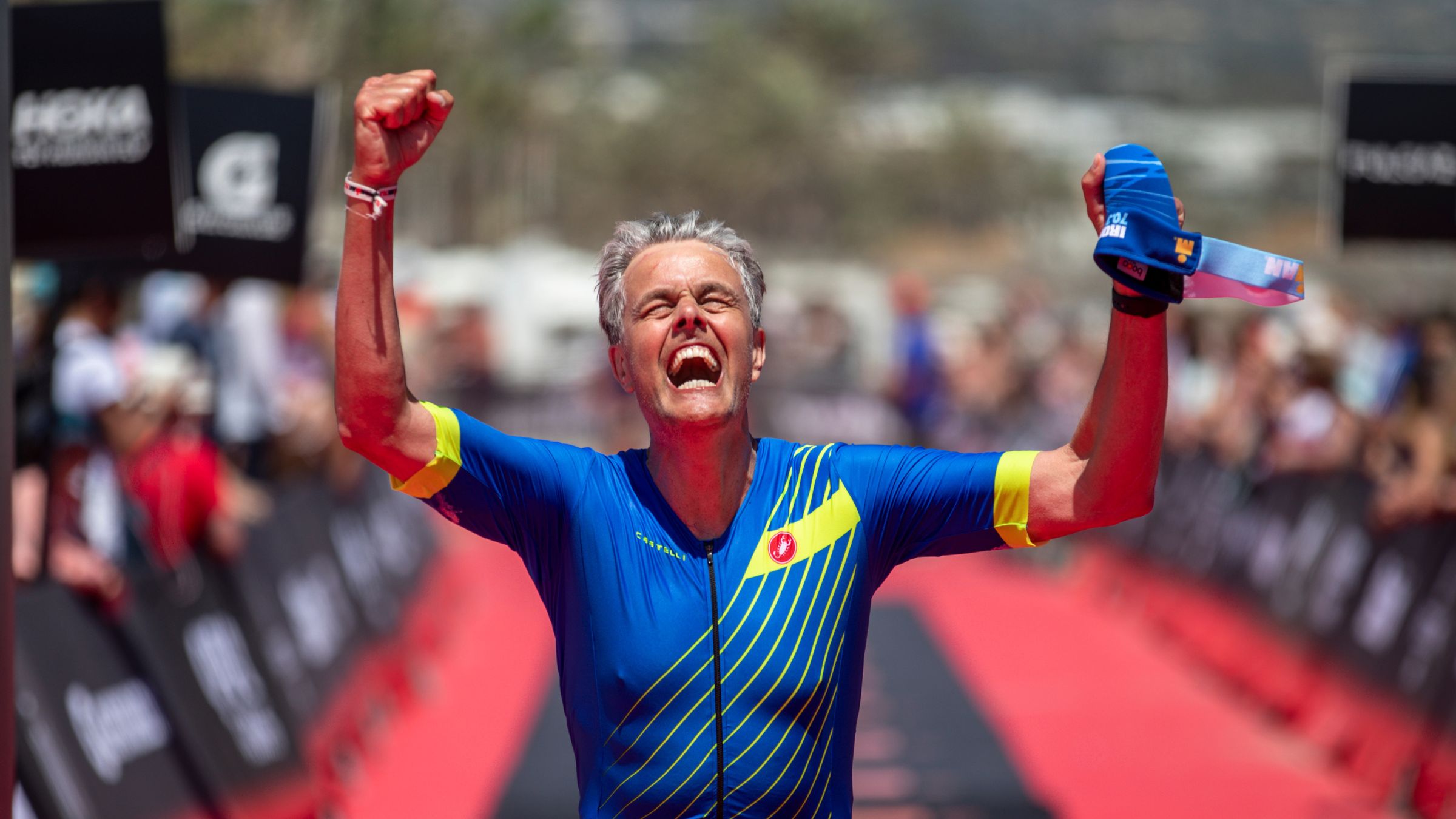 An athlete crosses the finish line of his race with a good triathlon time