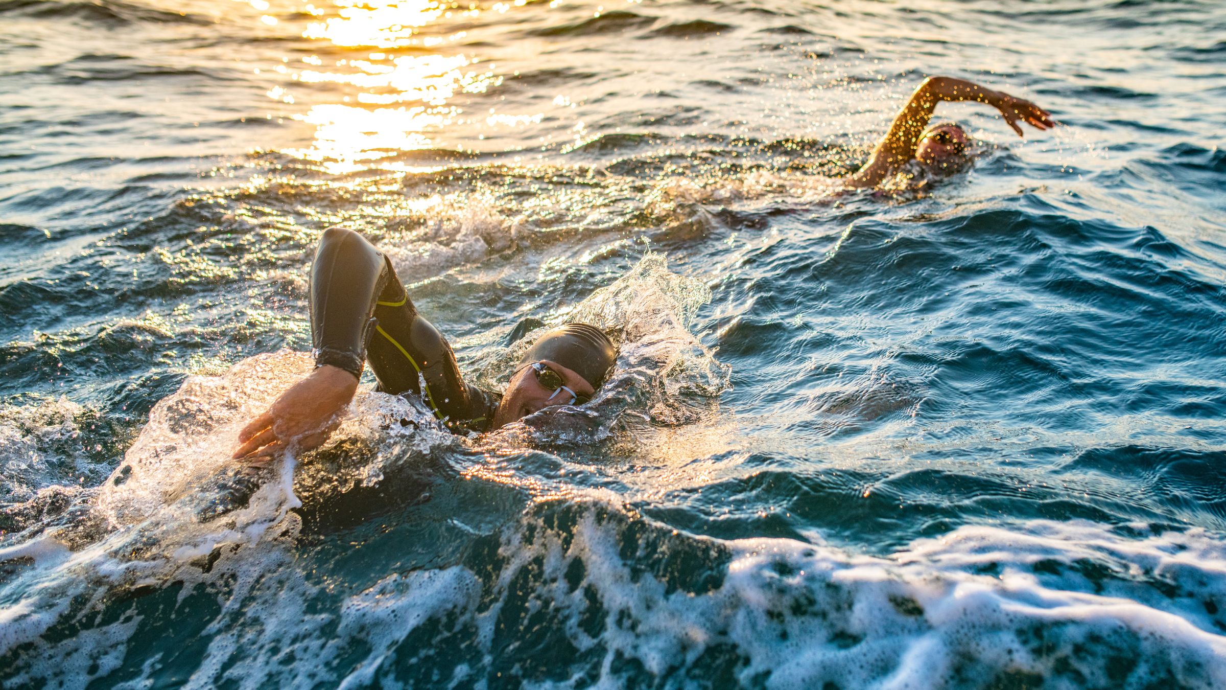 Two triathletes demonstrate how to breathe when swimming