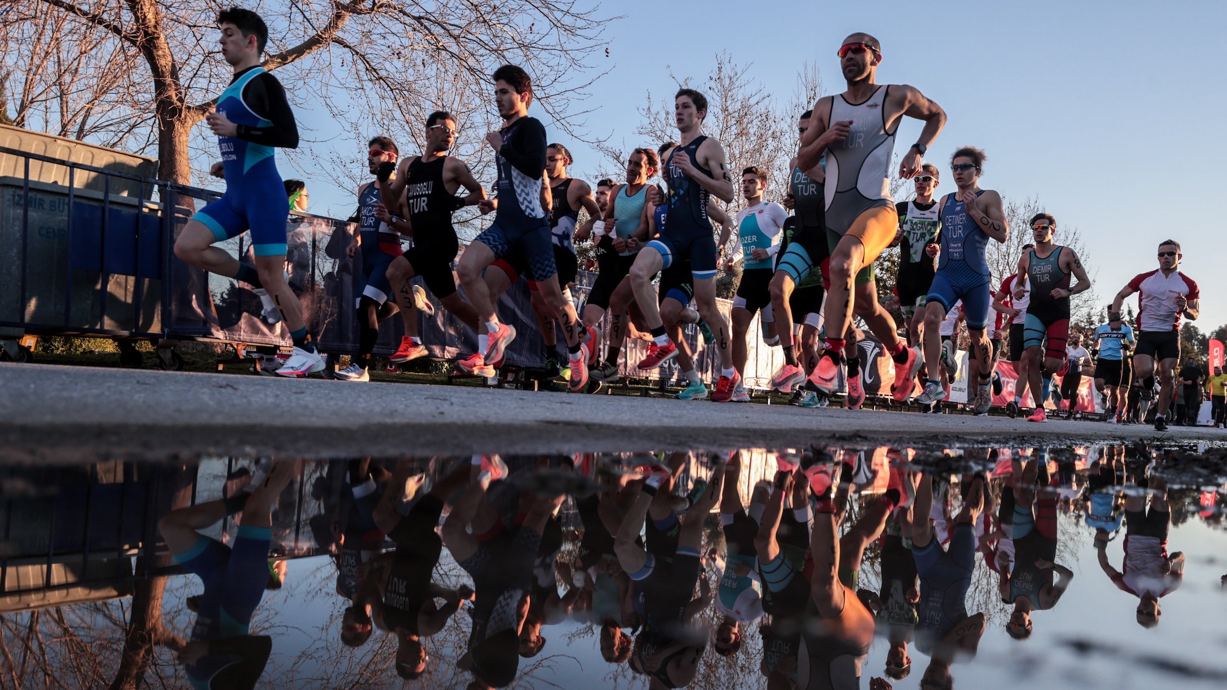 duathletes running in Turkey, reflected in the water