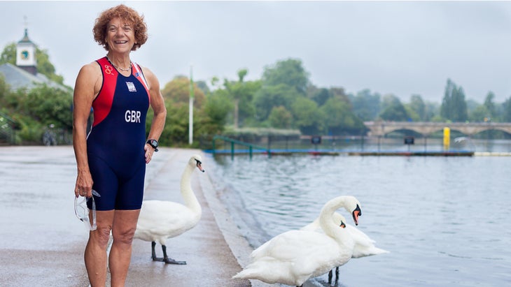 Eddie Brocklesby in a tri wetsuit next to swans at a body of water
