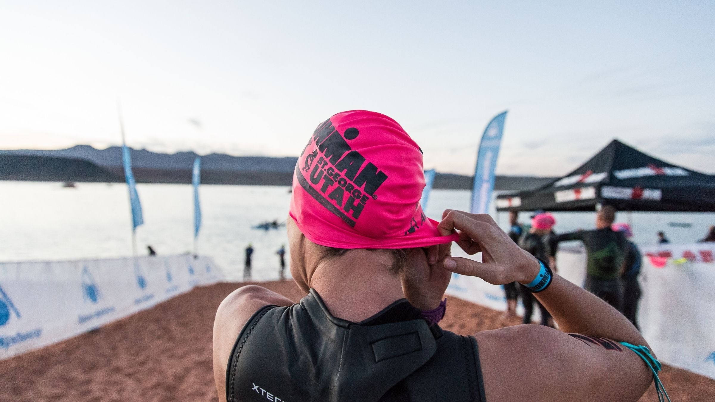An athlete preps her swim cap before the start of the Ironman St. George swim in St. George, Utah.