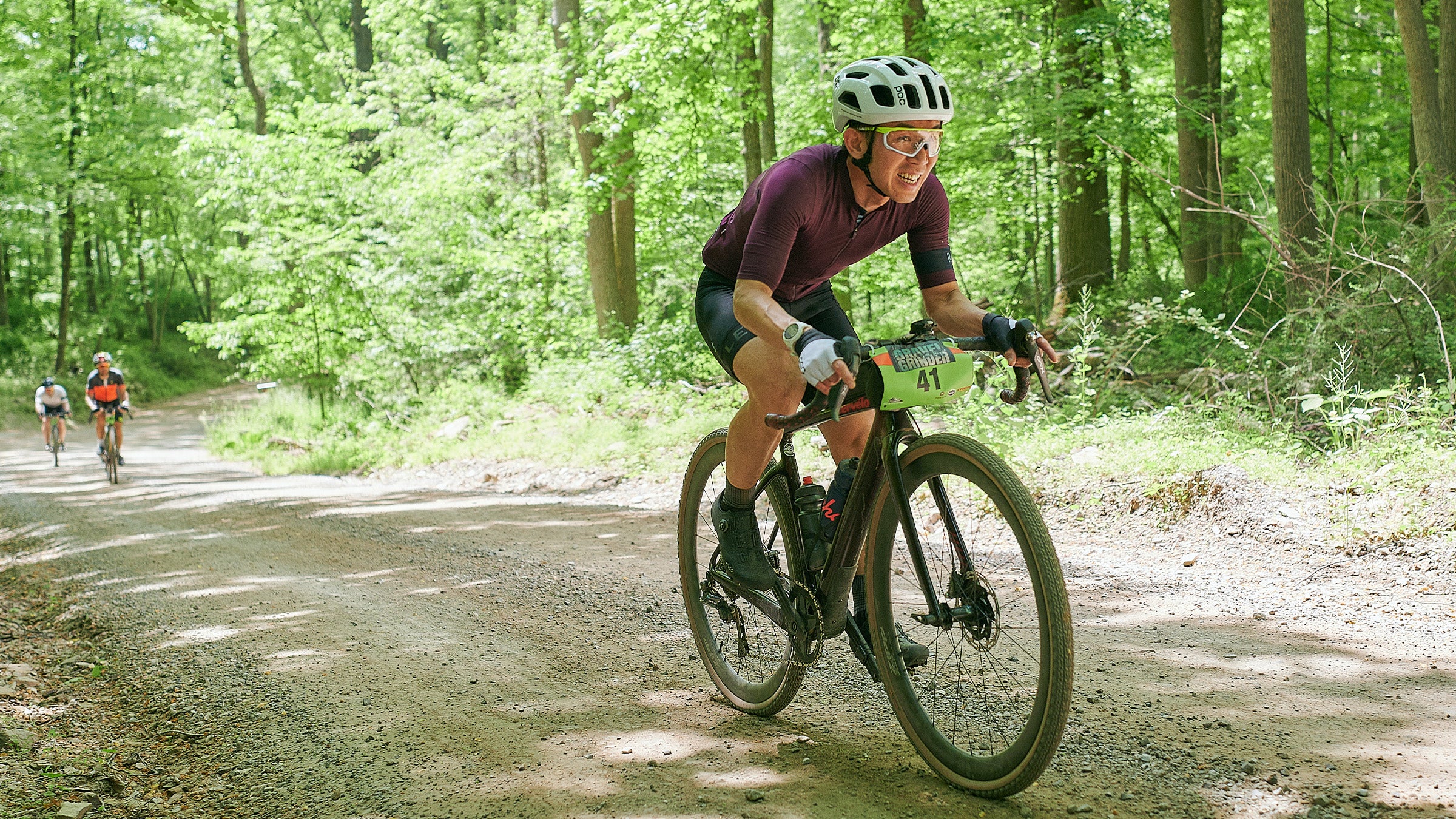 Gravel race participant leading other contestants through the woods