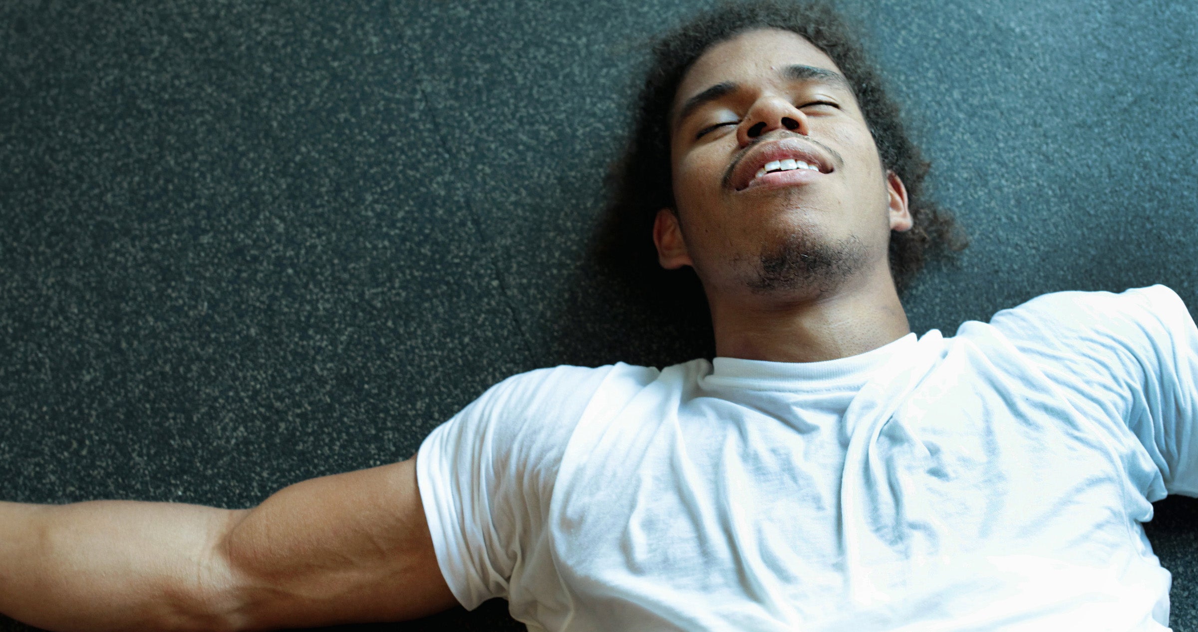 Young hispanic male doing intense physical workout in the gym