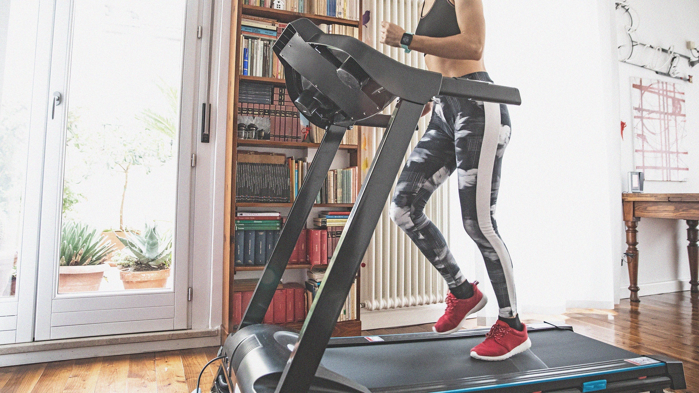 woman running on a treadmill in her home gym