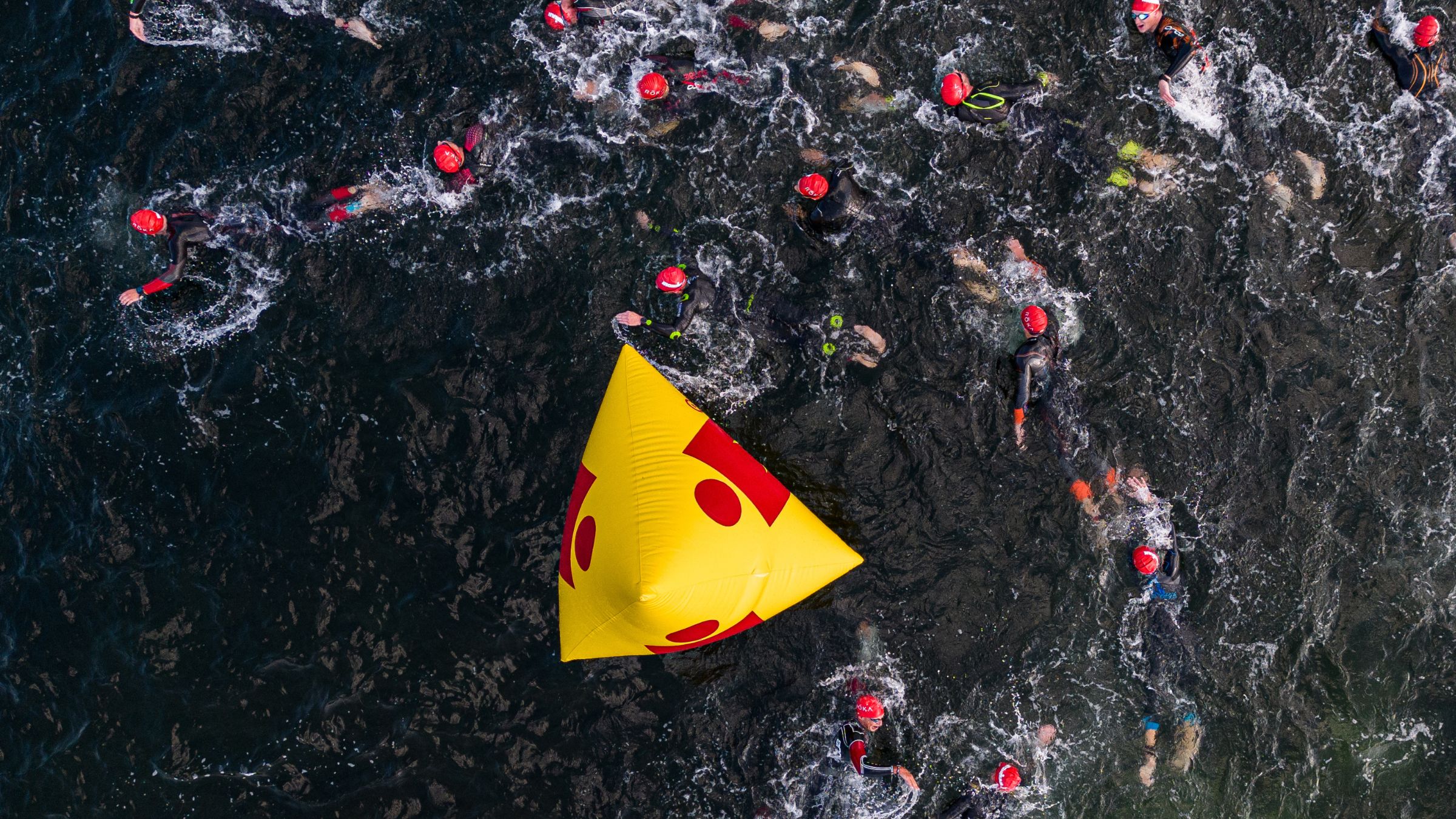 People swim around a turn buoy in a triathlon