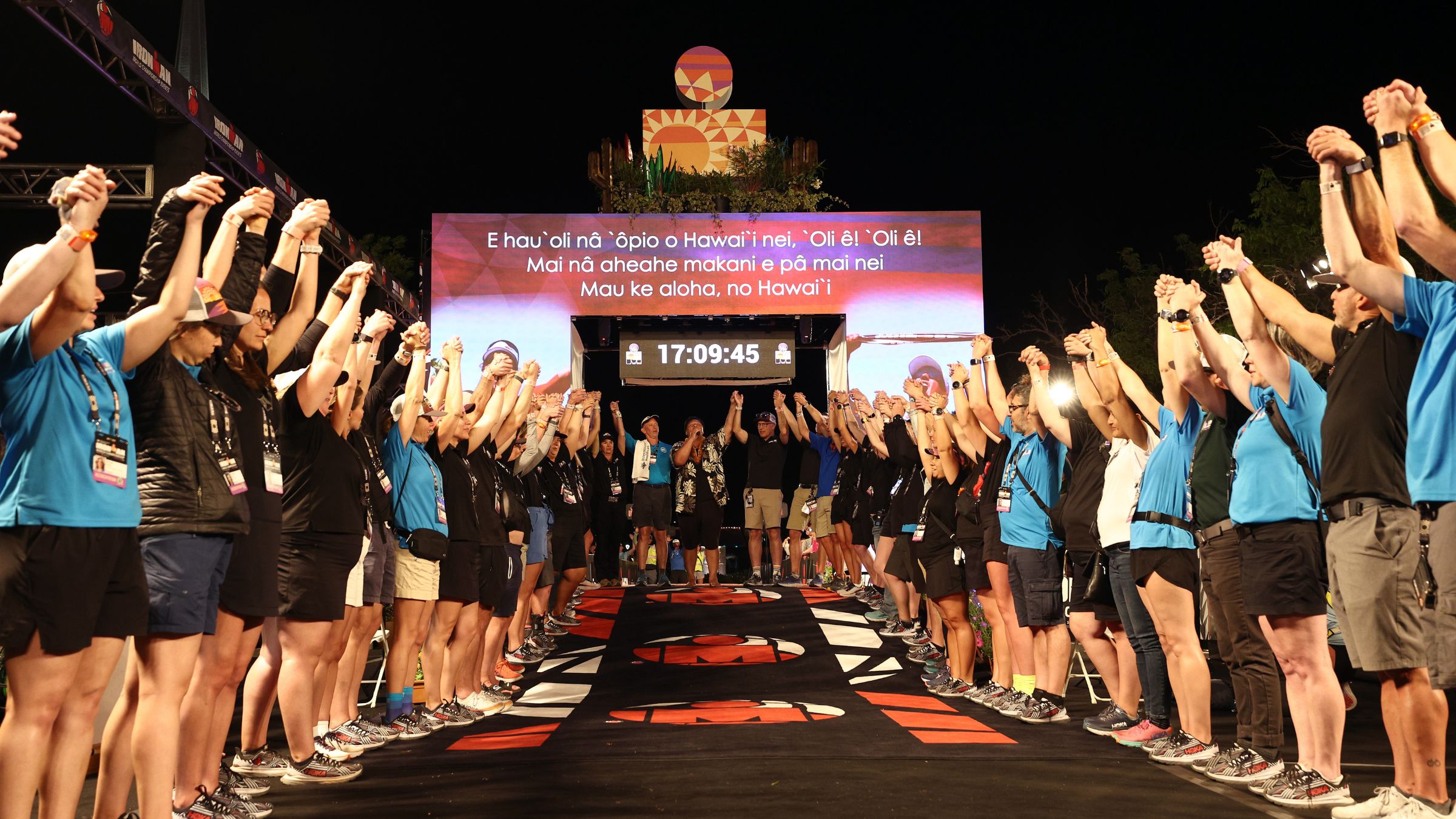 Volunteers line the finishing chute of the Ironman World Championship in Kona