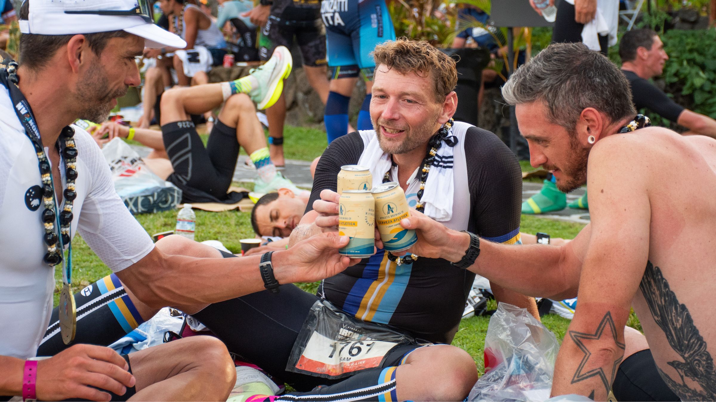 Triathletes toast their beers after a race.