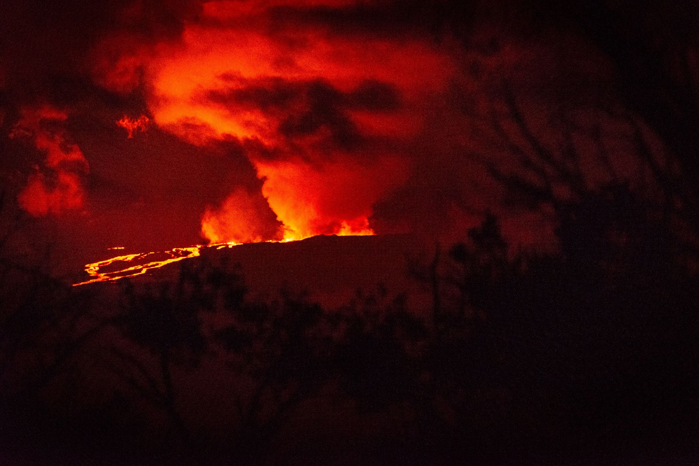 Mauna Loa erupts for the first time since 1984 on Hawaii Island, on November 28, 2022. - The world's largest active volcano burst into life for the first time in 40 years, spewing lava and hot ash Monday in a spectacular display of nature's fury by Mauna Loa in Hawaii. Rivers of molten rock could be seen high up on the volcano, venting huge clouds of steam and smoke at the summit on Big Island, and sparking warnings the situation could change rapidly. (Photo by Ronit FAHL / AFP) (Photo by RONIT FAHL/AFP via Getty Images)