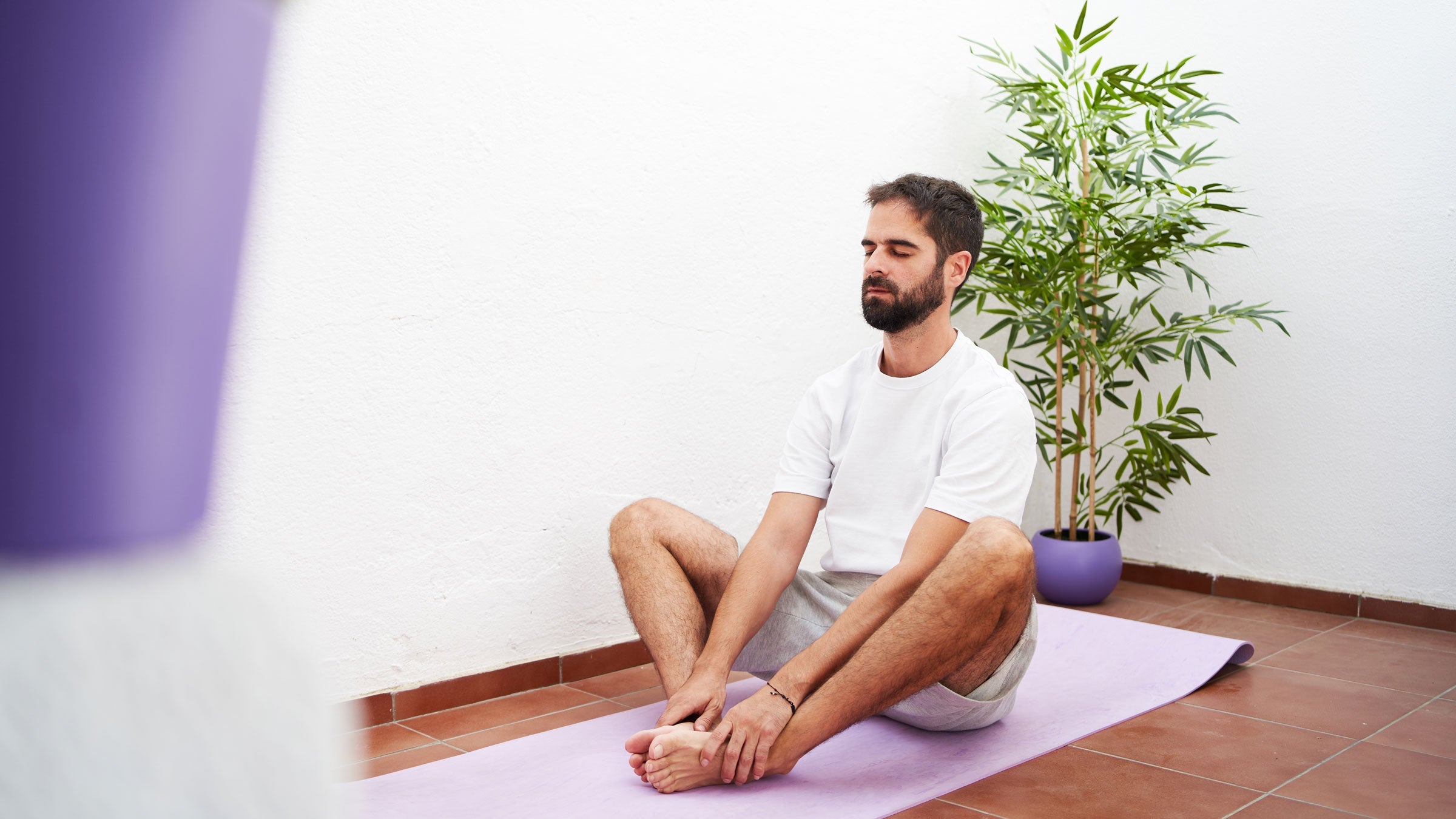 Man stretches his hips in a butterfly stretch