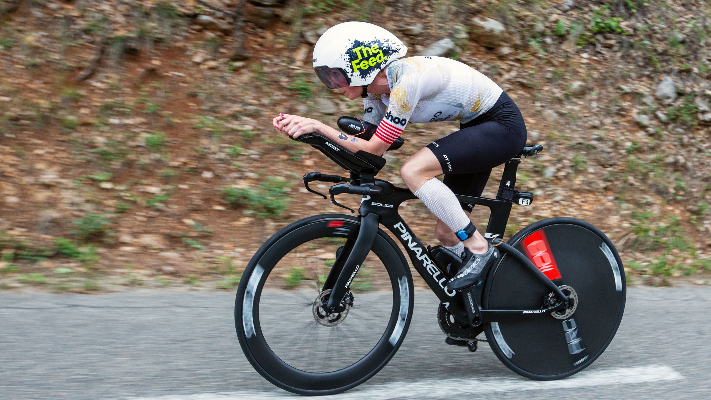 woman riding bike in aero position on road